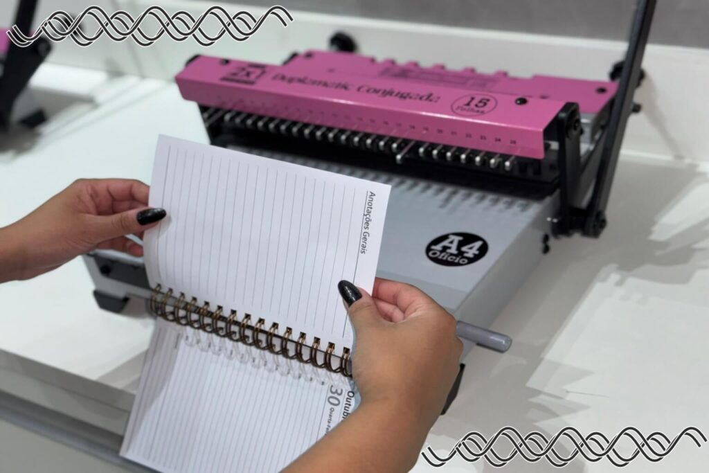 Inserção das folhas no wire-o durante o processo de encadernação